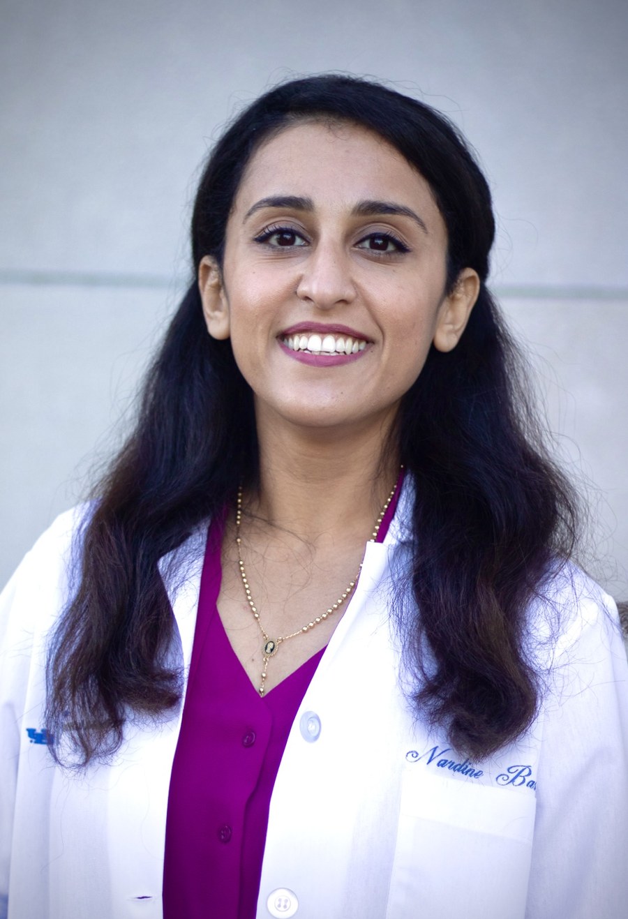 Dr. Nardine Bastawros, DDS, smiling in a white coat